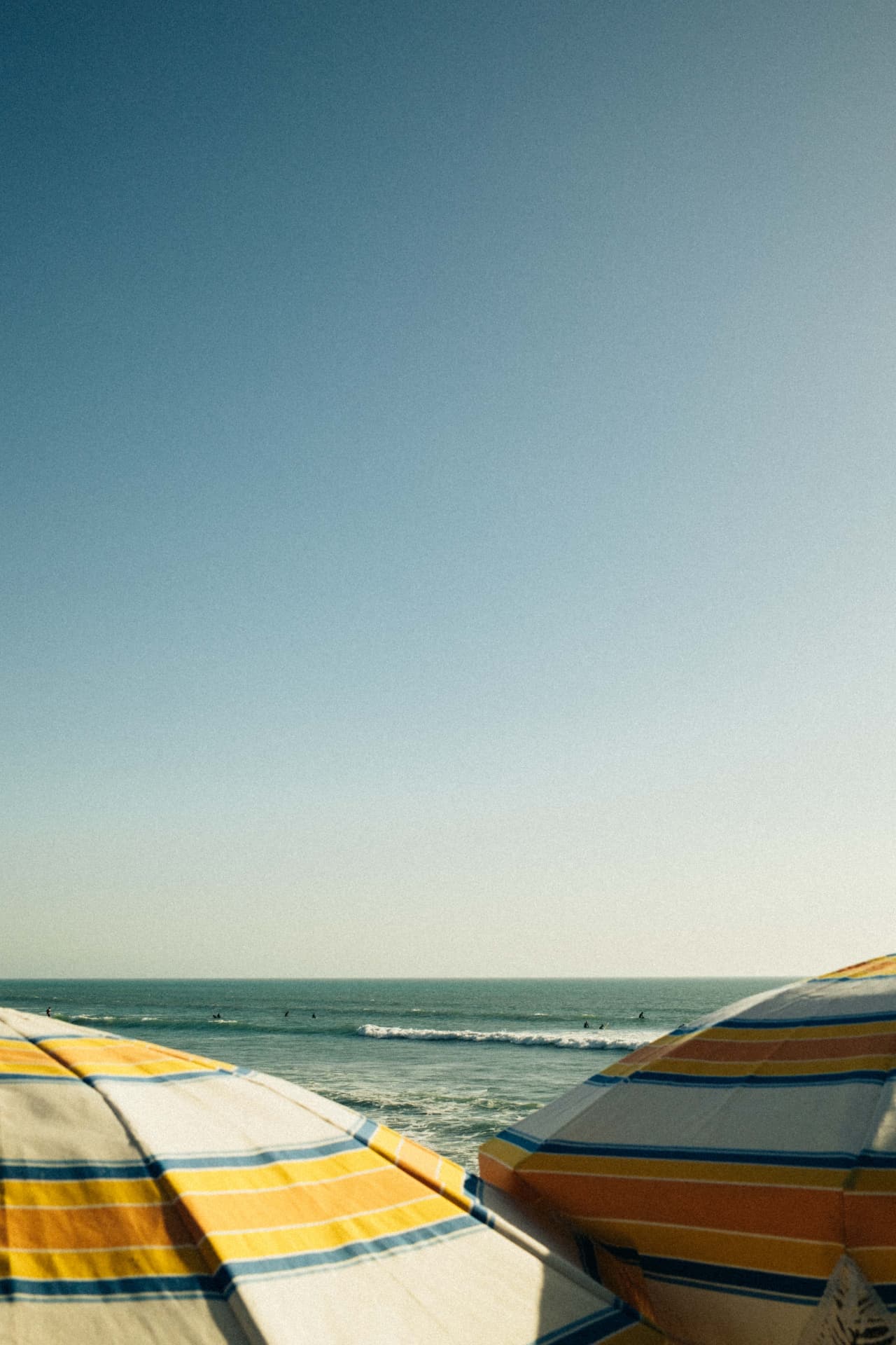 Parasols et surfeurs sur la plage d'Essaouira